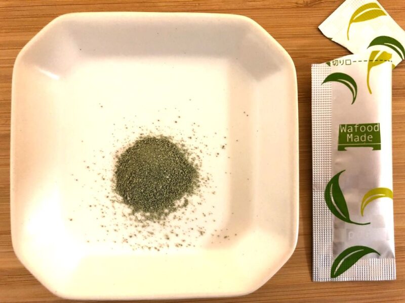 白い皿の上に宇治抹茶酵素洗顔の緑色のパウダーを1包分入れている。